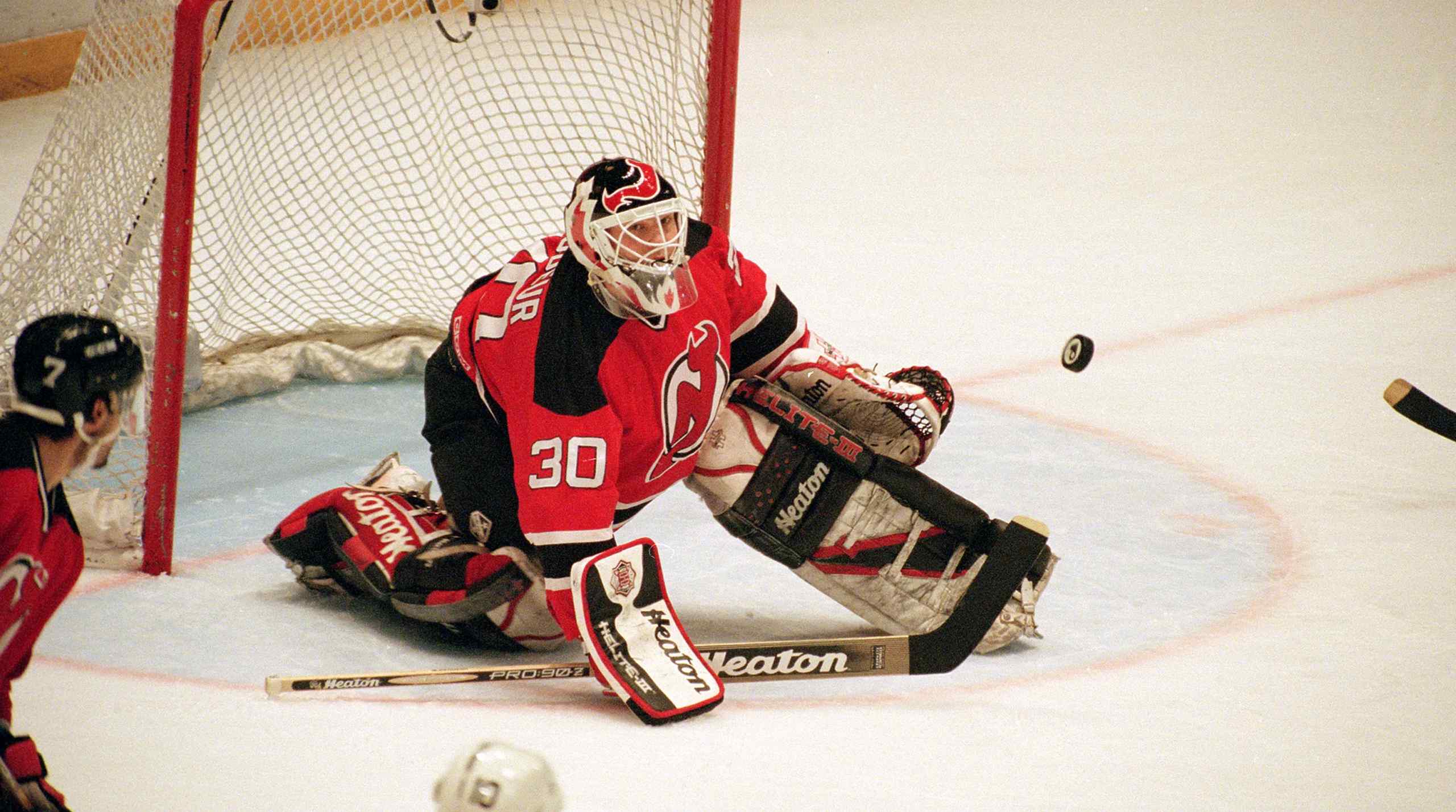 New Jersey Devil's goaltender Martin Brodeur looking at a puck.